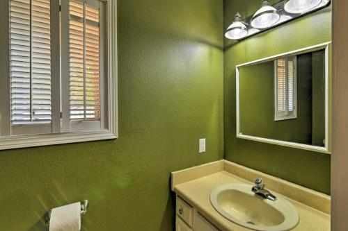 a green bathroom with a sink and a mirror at Charming Anchorage Home with Grill and Deck! in Anchorage