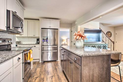 a kitchen with white cabinets and a stainless steel refrigerator at Modern Home with Yard and Deck, 1 Mi to Clemson U! in Clemson