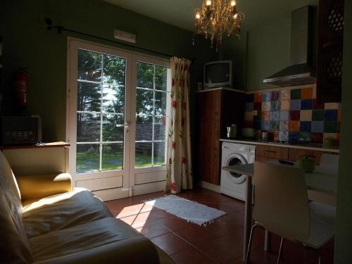 a living room with a couch and a kitchen with a window at Apartamentos Guidan in Ribadeo