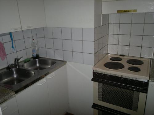 a kitchen with a sink and a stove at Partiotalon retkeilymaja - Scouts Hostel in Joensuu