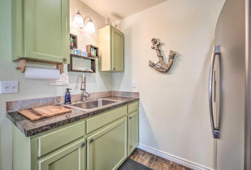 a kitchen with green cabinets and a refrigerator at Half-Mi to Seadrift Harbor Seadrift Home with Deck in Seadrift