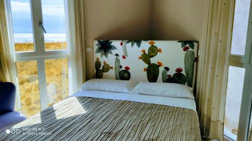 a bedroom with a bed with a mural of cactus at Torre dei Pirati in Letojanni