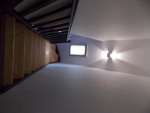 ein leeres Zimmer mit einem Licht an der Wand und einem Fenster in der Unterkunft Gite du nuage in Fontenay-Torcy