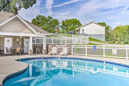a swimming pool in front of a house with a white fence at Home with Community Pool - 2 Miles to The Island! in Pigeon Forge