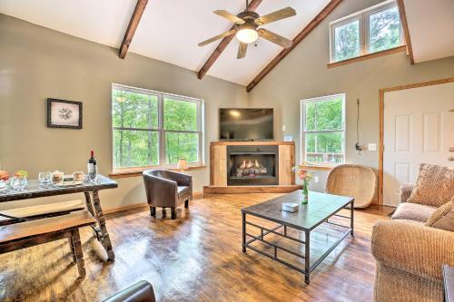 a living room with a ceiling fan and a fireplace at Hike and Zip-Line Red River Gorge Cabin with Hot Tub! in Rogers
