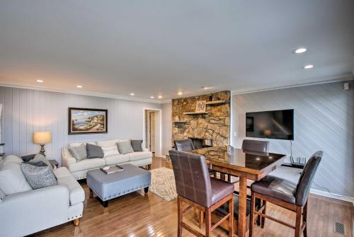 a living room with a table and a stone fireplace at Stay Above it All! Modern Home on Missionary Ridge in Chattanooga