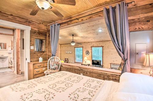 ein Schlafzimmer mit einem Bett und einer Badewanne im Bad in der Unterkunft Updated Cabin with Porch, Mins to Cossatot River in Wickes