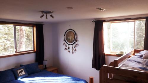 a bedroom with two beds and two windows at Wettstone Guest Ranch in Bridge Lake