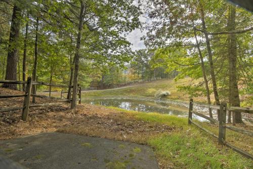 a wooden fence next to a river with trees at Couples Cabin - 5 Mi to DT Berkeley Springs! in Berkeley Springs