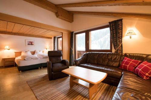 sala de estar con sofá y cama en B&B La Tambra - central with Restaurant en Santa Cristina in Val Gardena