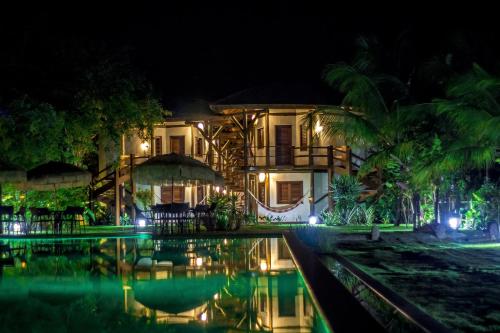 a house with a swimming pool at night at Hotel Villa Balidendê in Barra Grande