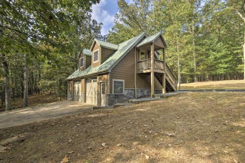a house with a wrap around porch in the woods at Couples Cabin - 5 Mi to DT Berkeley Springs! in Berkeley Springs