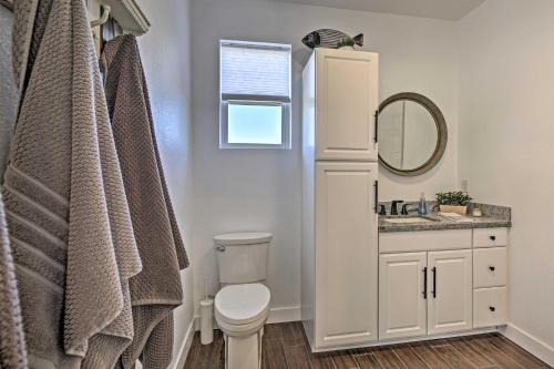 a bathroom with a toilet and a sink and a mirror at Cottage by the Lakes with Hot Tub by Lake Nacimiento in Oak Shores