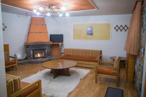 a living room with a table and a fireplace at Exohiko in Palaios Agios Athanasios