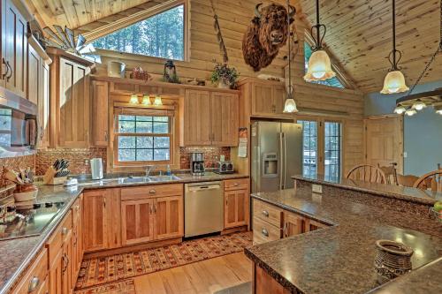 a large kitchen with wooden cabinets and a large island at Black Hills Cabin Hot Tub, Fishing Pond and Deck in Custer