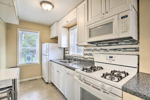a kitchen with white cabinets and a stove top oven at Kansas City Apt, Walk to KC MuseumandMed School in Kansas City