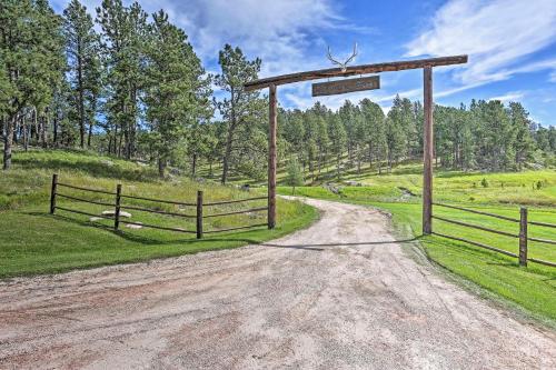 a dirt road with a gate and a fence at Black Hills Cabin Hot Tub, Fishing Pond and Deck in Custer