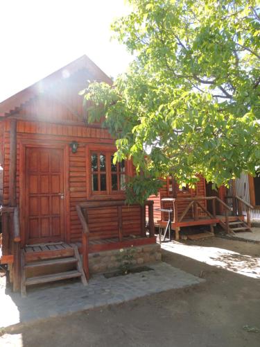 una cabaña de madera con un banco delante en Cabañas Teushen en Perito Moreno