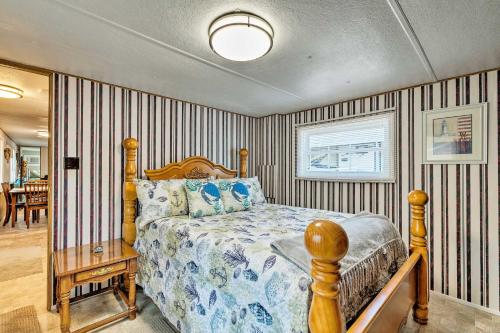 a bedroom with a bed and striped walls at Cabin with Fire Pit, Walk to Steinhatchee River! in Steinhatchee