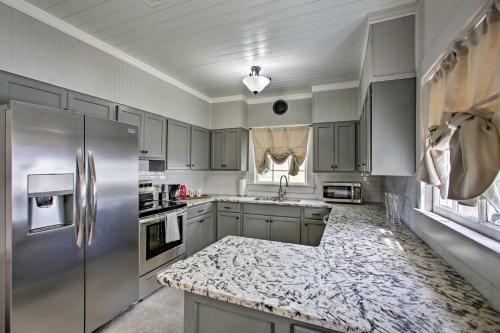 a kitchen with a stainless steel refrigerator and a counter at Charming Cottage with Mississippi River Views! in Natchez