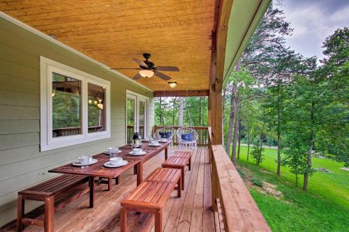 a wooden deck with a table and benches on a house at Home with Deck and Game Room - 8 Mi to Asheville in Fairview