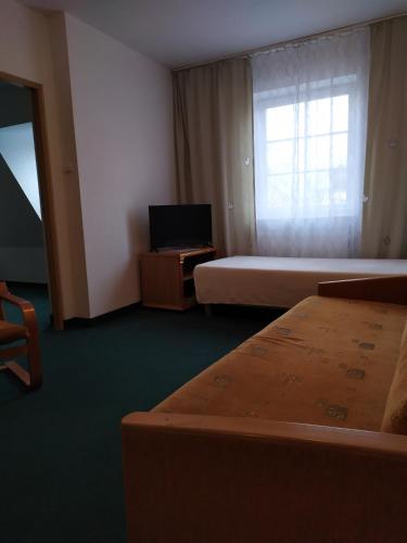 a hotel room with two beds and a television at Dom Turysty in Kostrzyn nad Odrą