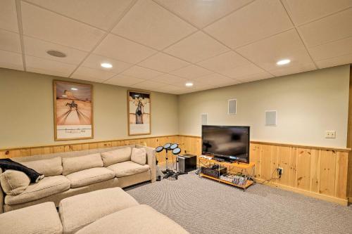 a living room with a couch and a flat screen tv at West Dover Home with Deck, Grill and EV Outlet in West Dover