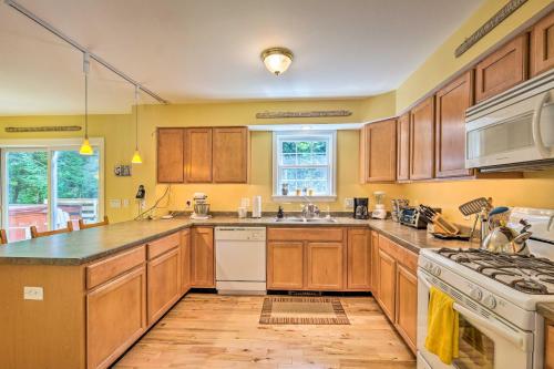a large kitchen with wooden cabinets and a sink at West Dover Home with Deck, Grill and EV Outlet in West Dover