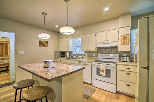 a kitchen with white cabinets and a counter with stools at Utopia Family Home, 2 Blocks to Utopia Park! in Utopia