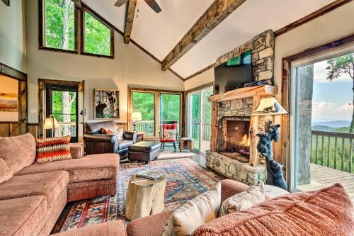 an open living room with a stone fireplace at 3 Mi to Beech Mtn Treetop Cabin with Deck and Views in Beech Mountain