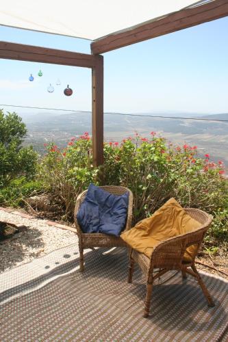 a wicker chair sitting on a porch with a view at Ananda in Hararit