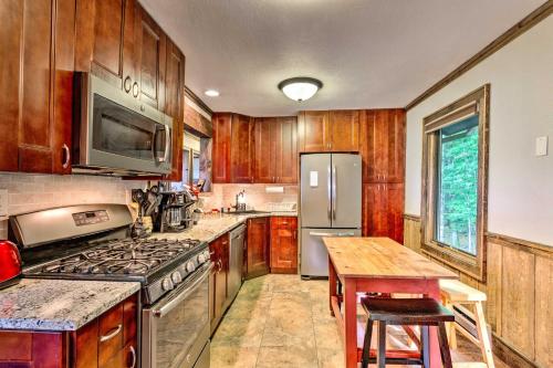 a kitchen with wooden cabinets and a stove and a table at 3 Mi to Beech Mtn Treetop Cabin with Deck and Views in Beech Mountain