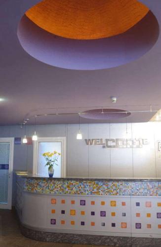 a lobby with a counter with a large ceiling at Hotel Com - All Inclusive in Albena