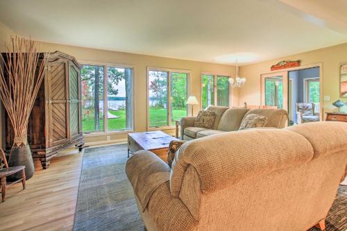 a living room with couches and a table and windows at Interlochen Home on Green Lake with Dock and Beach! in Interlochen