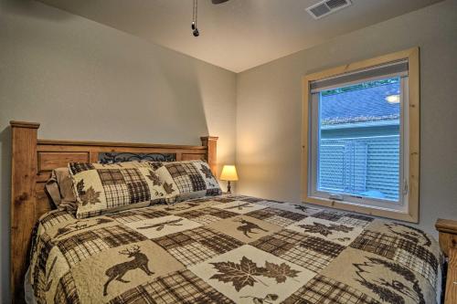 a bedroom with a bed and a window at Petoskey Area Cabin, Walk to Crooked River! in Alanson