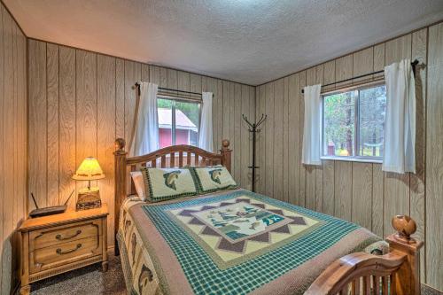 a bedroom with a bed and a lamp and a window at 2 Cozy Island Park Cabins with Near the Lake! in Island Park