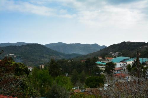 uitzicht op een stad met bergen op de achtergrond bij Aprosmeno Jacuzzi House 1 in Agros