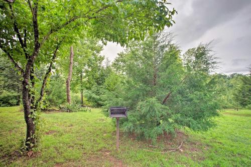 a bench sitting in a field next to a tree at Mill Spring Cabin Near Parker-Binns Winery! in Mill Spring