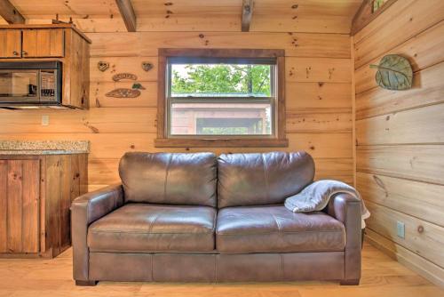 a leather couch in a room with a window at Mill Spring Cabin Near Parker-Binns Winery! in Mill Spring