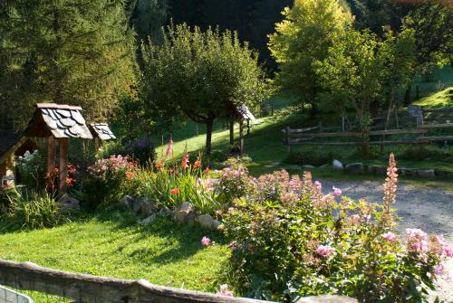 a garden with a bunch of flowers and trees at Auberge NEMOZ in La Ferrière