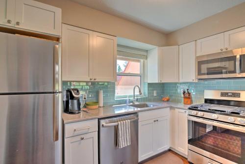 a kitchen with white cabinets and a stainless steel refrigerator at Bright Ruidoso Condo with Deck and Golf Course Views! in Ruidoso