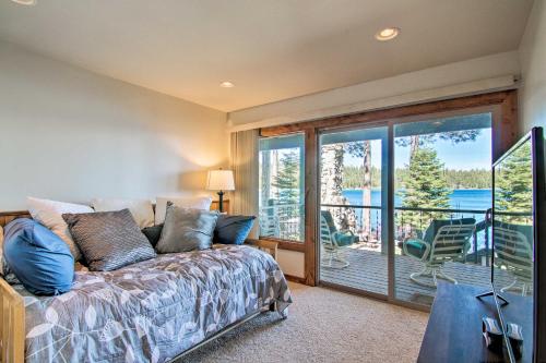 a bedroom with a bed and a balcony with a view at Dock Access and Hot Tub Waterfront Meeks Bay Home in Tahoma