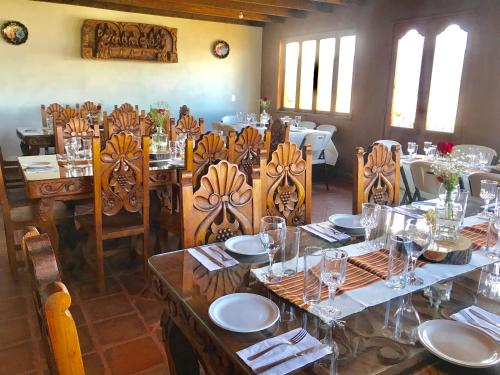 Un comedor con una mesa y sillas con vasos. en La Gloria de Los Ángeles, en Tzintzuntzán