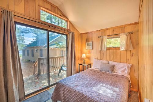 ein Schlafzimmer mit einem Bett und einem großen Fenster in der Unterkunft Lake Pleasant Cabin 3 Acres, Kayaks and Beach! in Lake Pleasant