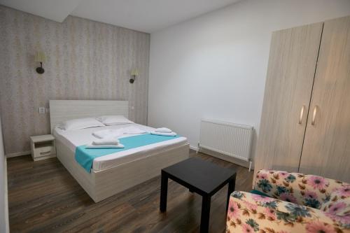 1 dormitorio con 1 cama y 1 silla en Stanford Guesthouse, en Bucarest