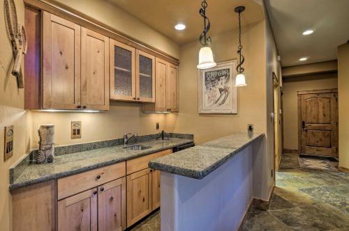 une cuisine avec des armoires en bois et des comptoirs en granit dans l'établissement Hilltop Breck Home Hot Tub, Views and Walk to Town, à Breckenridge