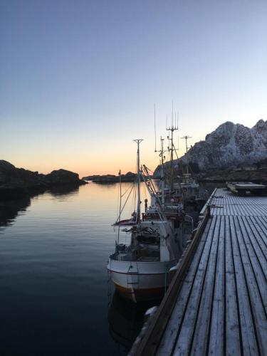 a group of boats docked at a dock in the water at Lofoten Sea Lodge in Sennesvik