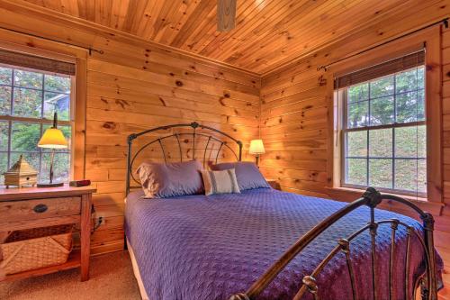 a bedroom with a bed in a log cabin at 11 Mi to Boone Secluded Pet-Friendly Cabin! in Todd