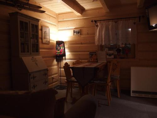 Pokój ze stołem, krzesłami i lampką w obiekcie Misia Chata w Zakopanem