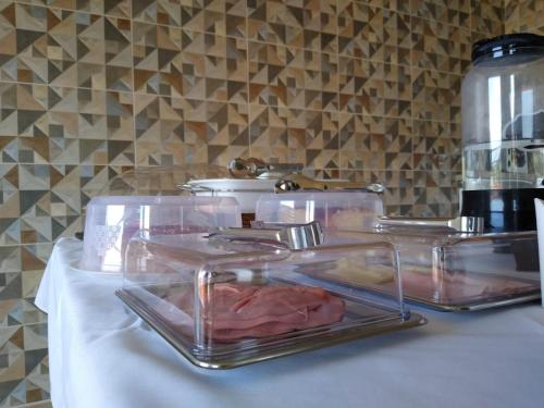a table with clear trays of food on it at Hospedagem Joanópolis in Joanópolis